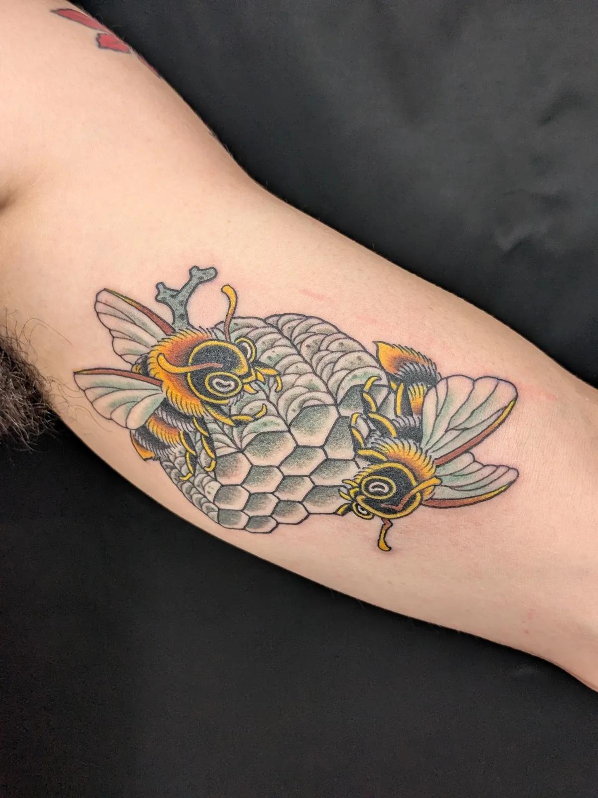 Bees and honeycomb tattoo on the upper arm