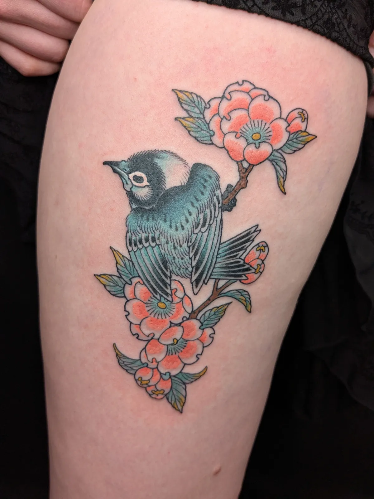 Bird and camellia tattoo on the thigh