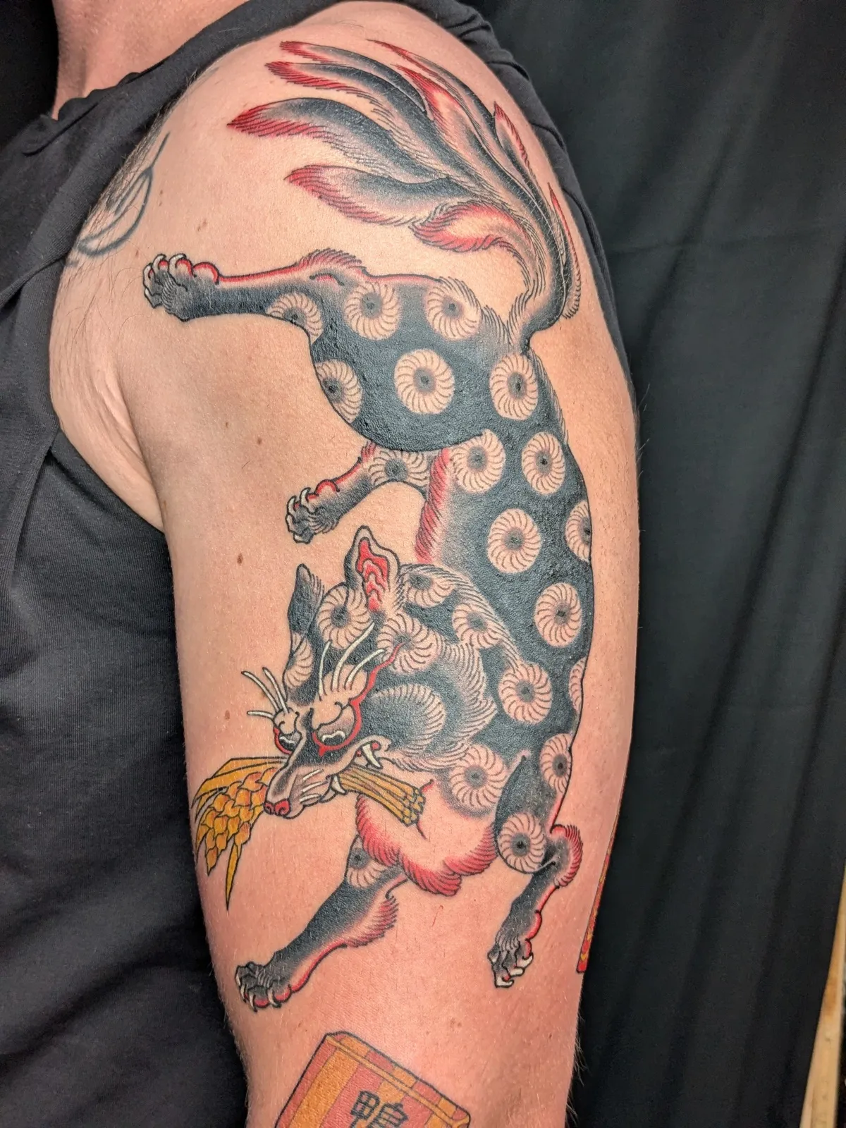 Nine-tailed fox tattoo on the upper arm