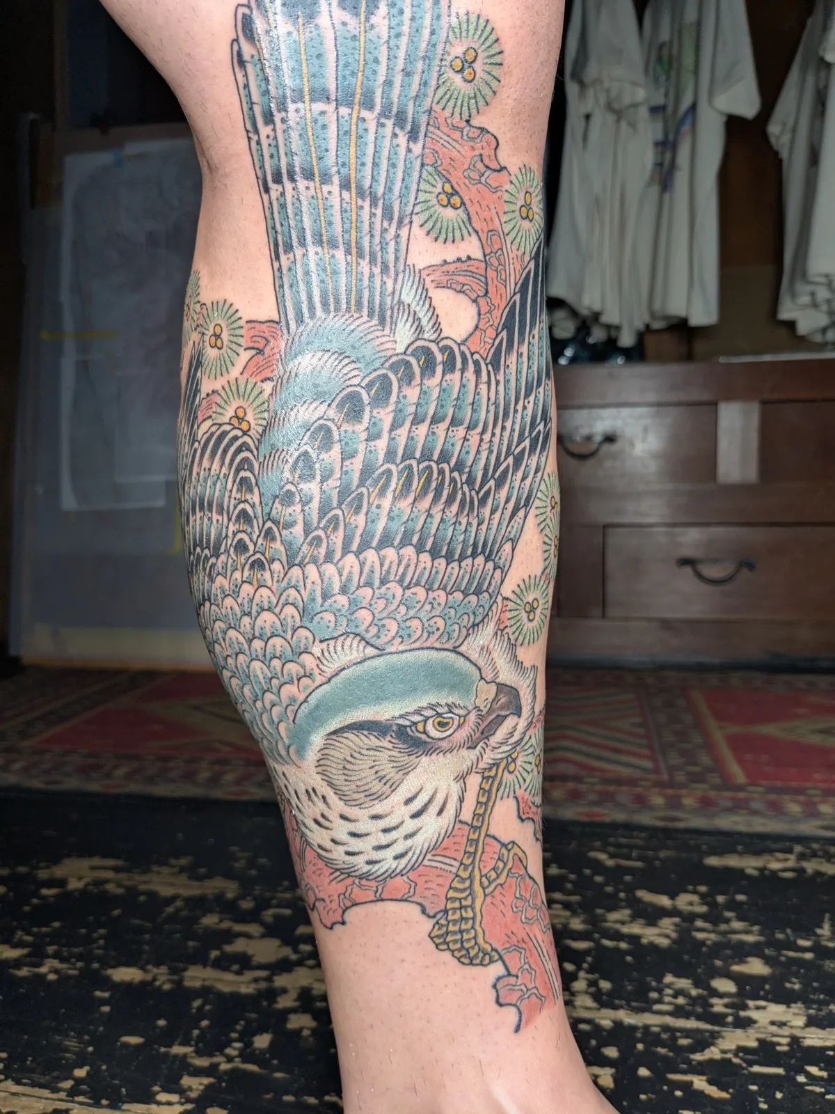 Hawk and pine tattoo on the calf