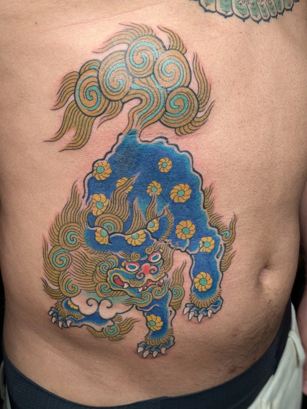 Guardian lion tattoo on the ribs