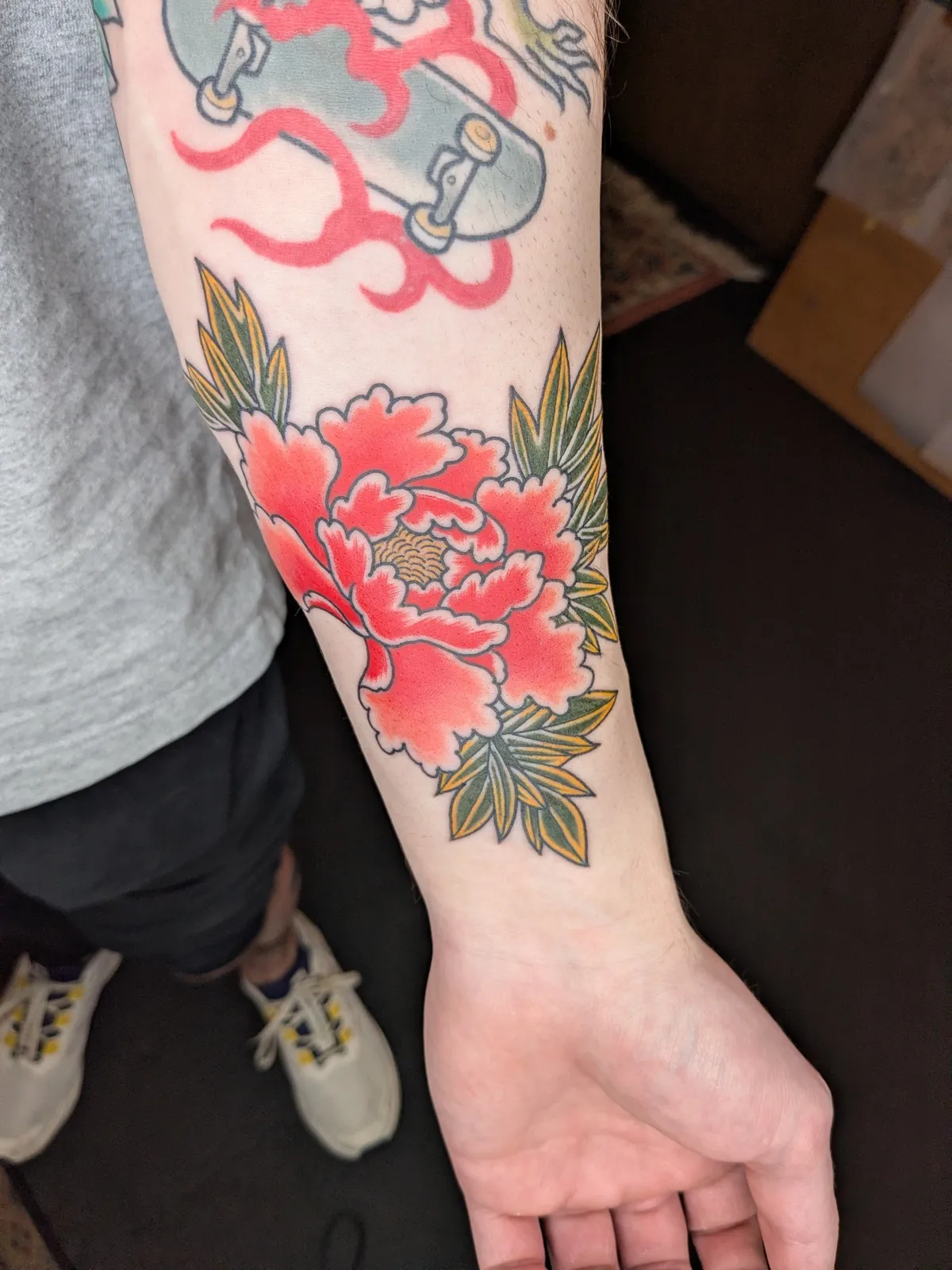 Peony and maple tattoo on the forearm