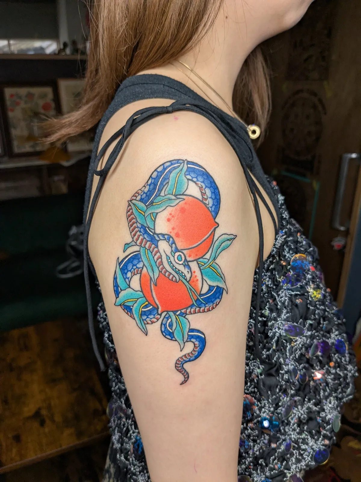 Snake and peach tattoo on the upper arm