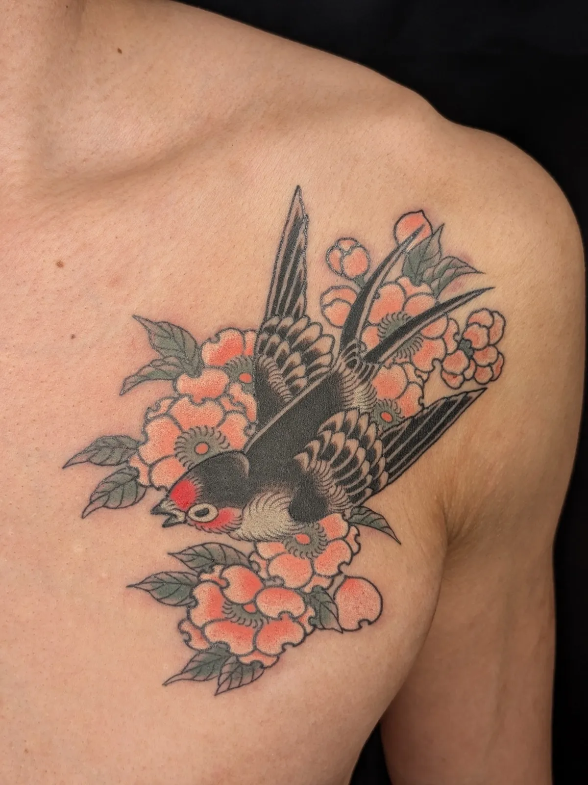 Swallow and blossom tattoo on the chest