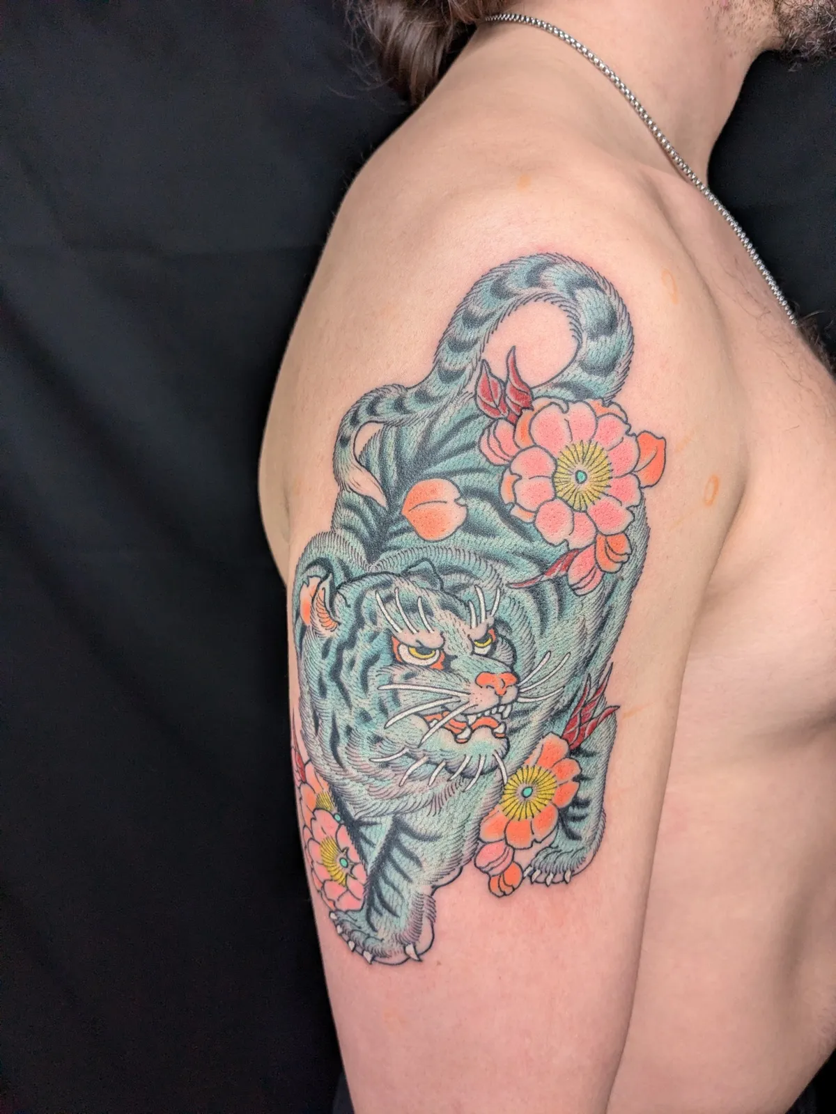 White tiger and cherry blossom tattoo on the upper arm