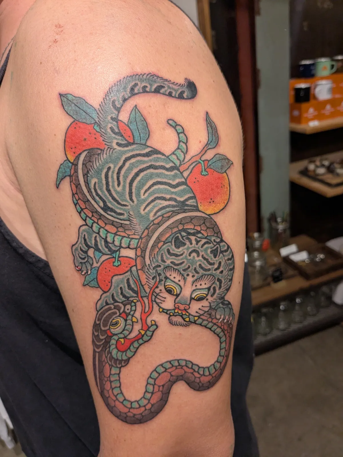 Tiger and snake tattoo on the upper arm