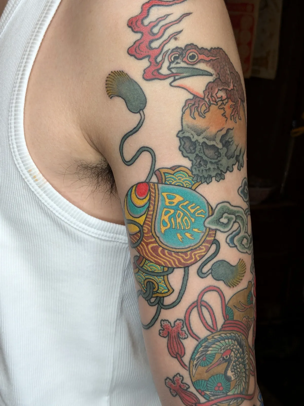 Toad and mallet tattoo on the upper arm